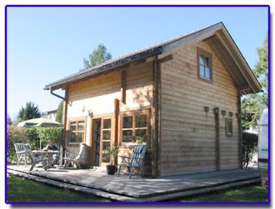 マットゼーにあるFerienblockhausの小さな木造の家で、パティオとテーブルが備わります。