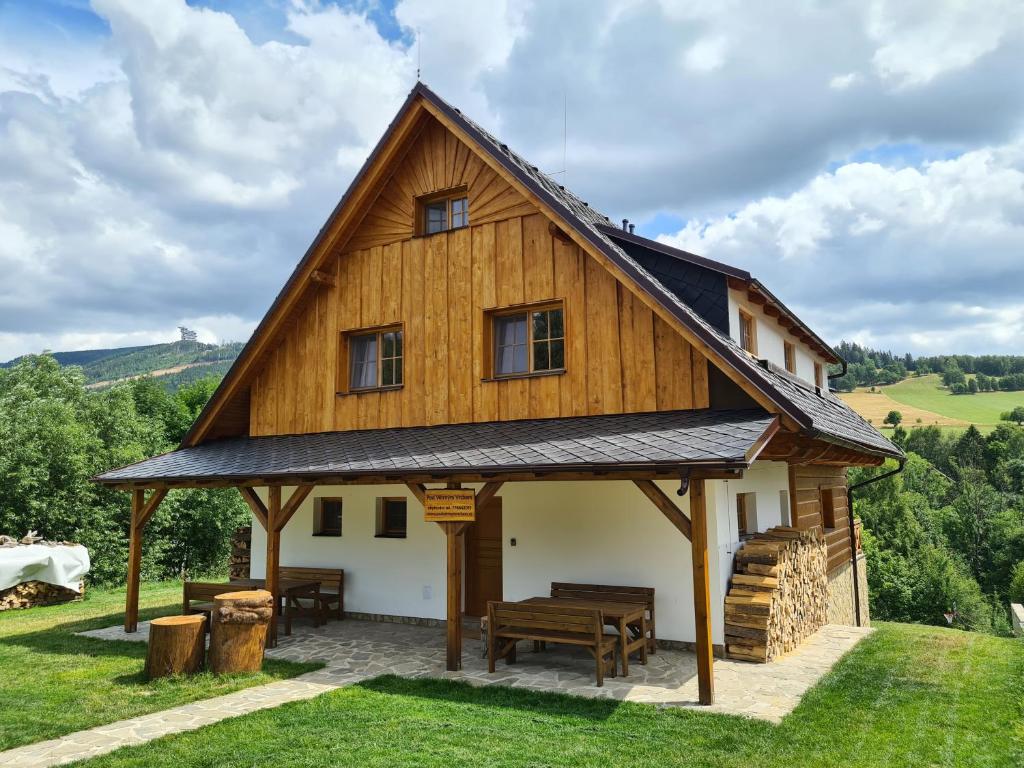duży drewniany dom z dachem gambrel w obiekcie Chalupa Pod Větrným Vrchem w mieście Dolní Morava