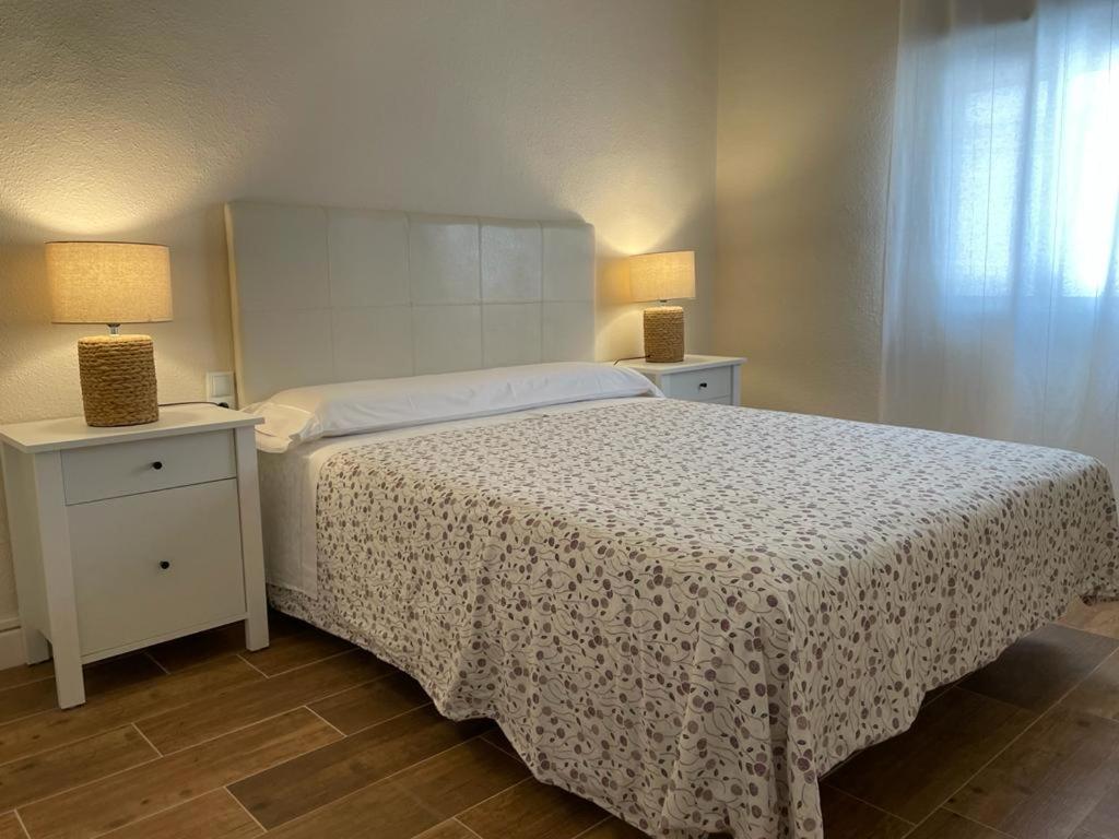 een slaapkamer met een bed en twee nachtkastjes met lampen bij Rural Confort Cataluña-Sur in Campredó