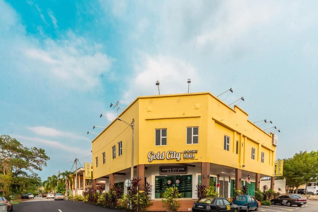 un edificio amarillo al lado de una calle en Gold City Hotel en Melaka