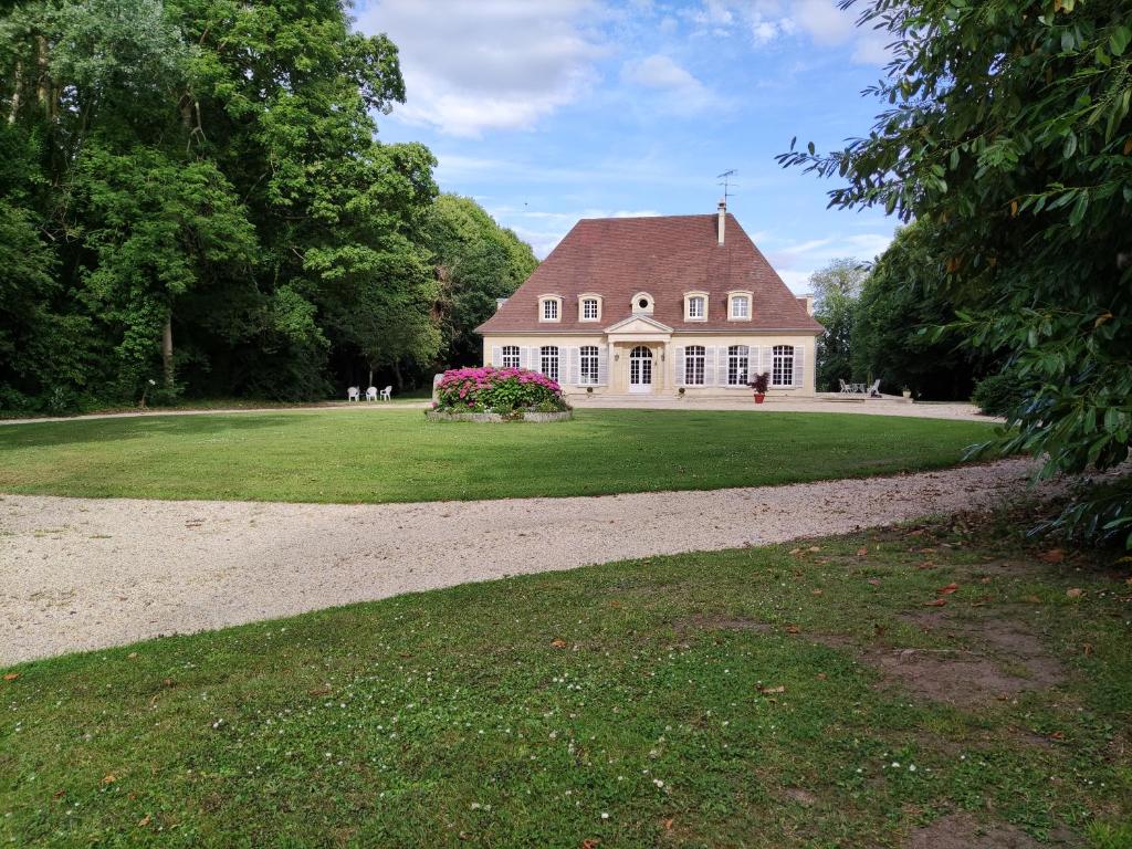 une grande maison blanche avec un toit marron dans l'établissement chambre SIXTIES, à Lingèvres