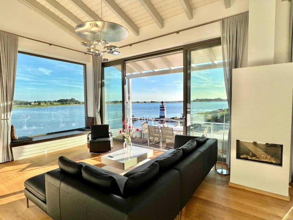 a living room with a couch and a view of the water at Apt "Sunset Lounge" in Waase - Ummanz - Meerblick, Kamin, Sauna in Mursewiek