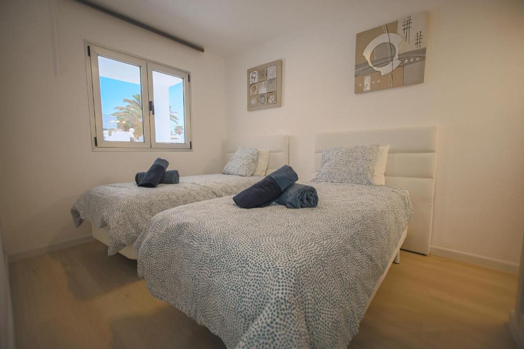 a bedroom with three beds with pillows on them at Apartment 1 Rociega 35 Puerto del Carmen in Puerto del Carmen