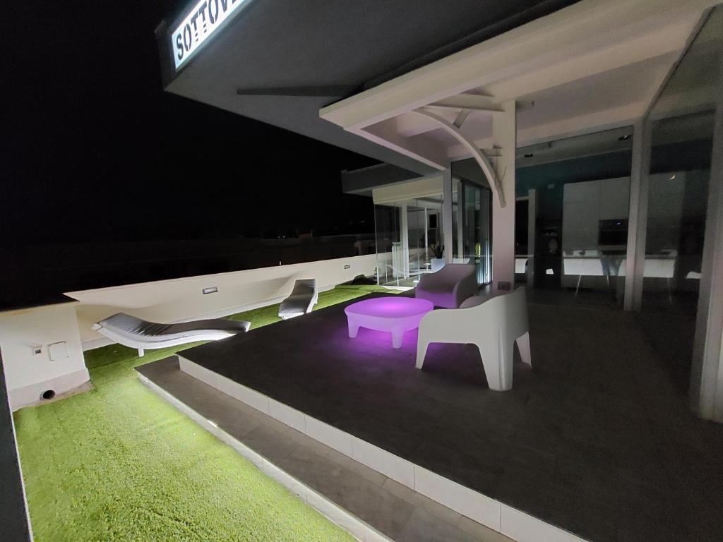 a room with a purple table and chairs at night at attico sottovento in Reggio Calabria