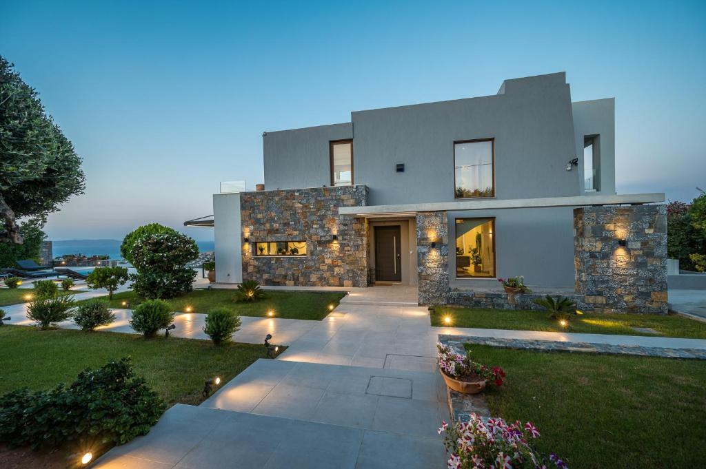 a house with a pathway leading to a yard with lights at Eunoia Villa Crete in Prasás