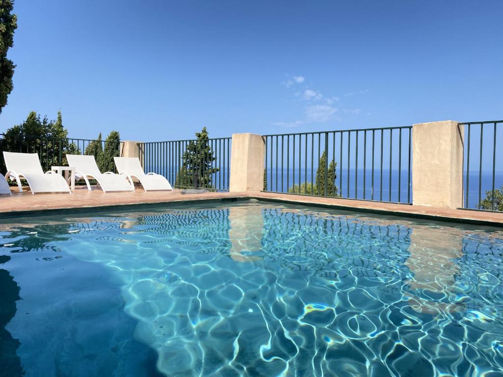 a swimming pool with white lounge chairs on a building at Alconasser 2 - Amazing Seaviews between Deia & Soller in Sóller
