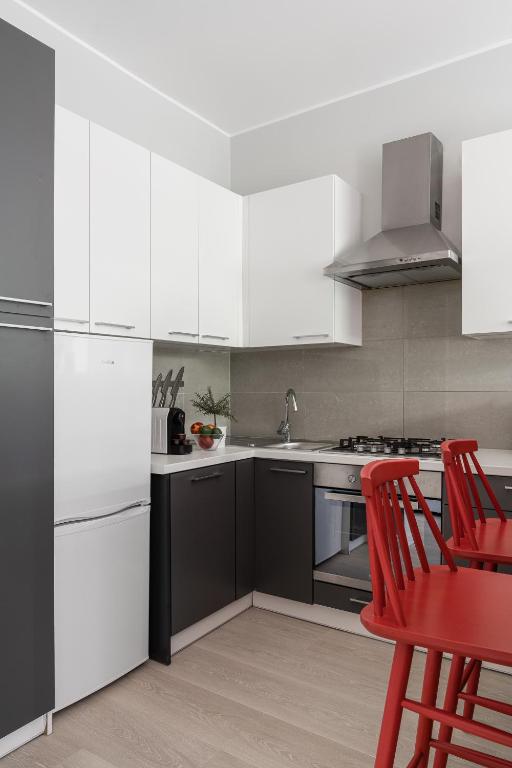 kuchnia z białymi urządzeniami i czerwonymi krzesłami w obiekcie Sanhaus Apartments - PLAYA 2 - Apartament przy samej plaży w mieście Sopot