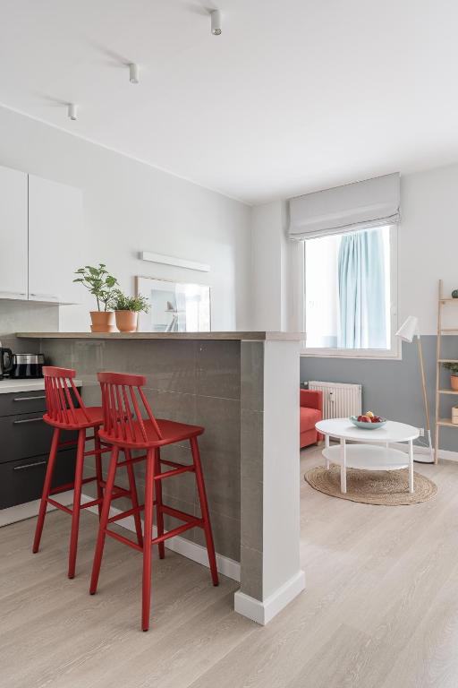 kuchnia z 2 czerwonymi krzesłami i stołem w obiekcie Sanhaus Apartments - PLAYA 2 - Apartament przy samej plaży w mieście Sopot