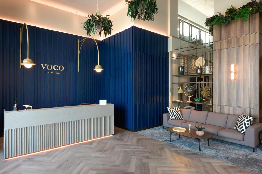 a lobby with a couch and a blue wall at voco Venice Mestre - The Quid, an IHG Hotel in Mestre
