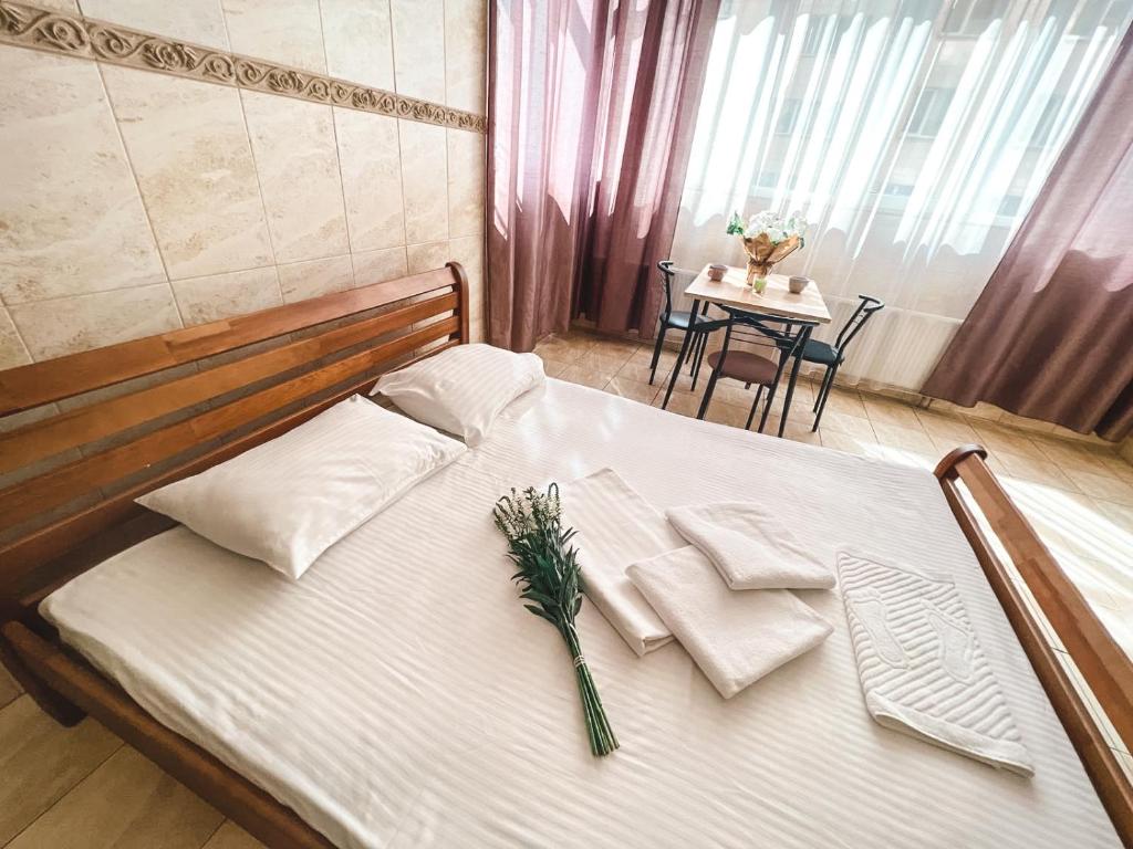 a white bed with a bouquet of flowers on it at Pechersk House in Kyiv