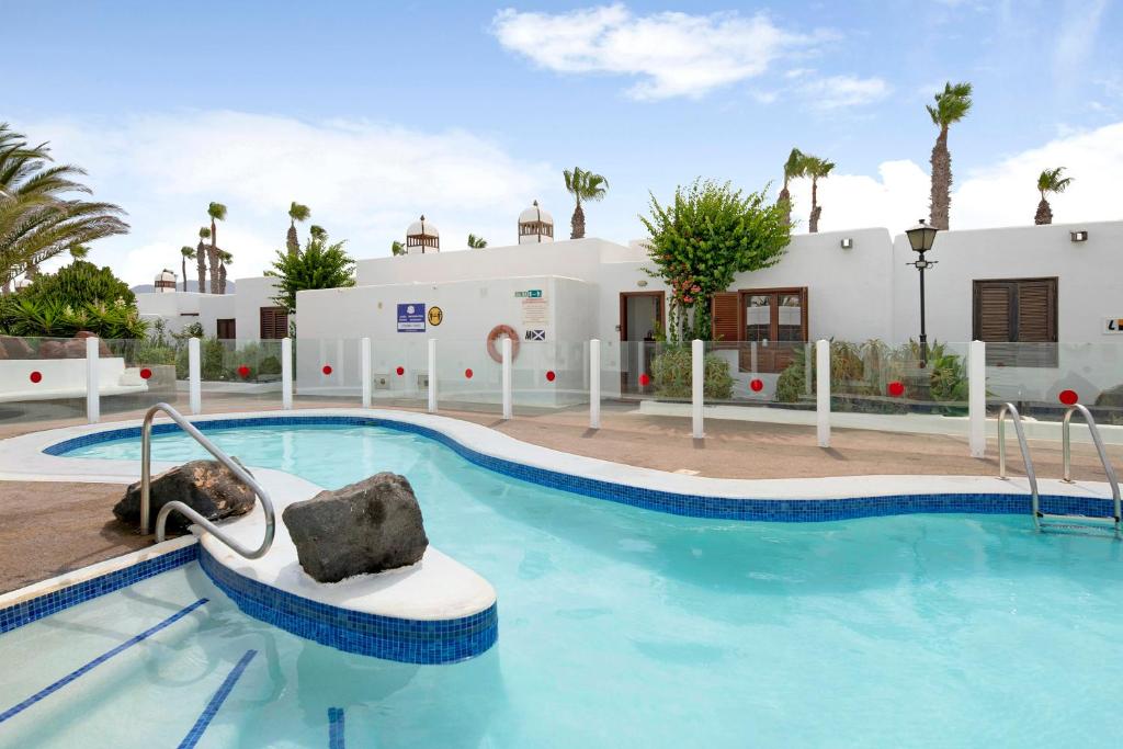 una piscina in un resort con una barca di Puerto Chico M a Playa Blanca