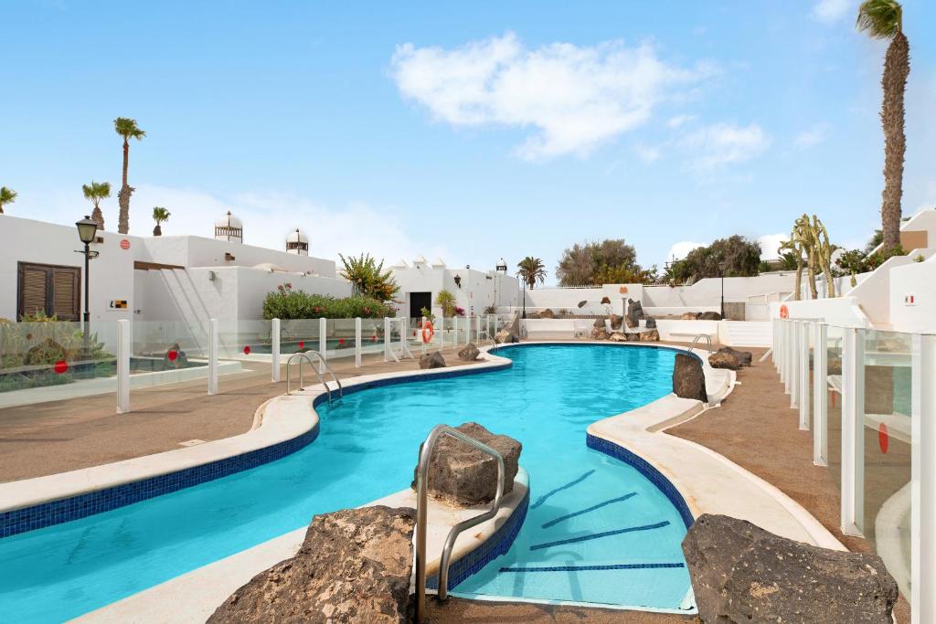 a pool at a resort with blue water at Puerto Chico 9 in Playa Blanca