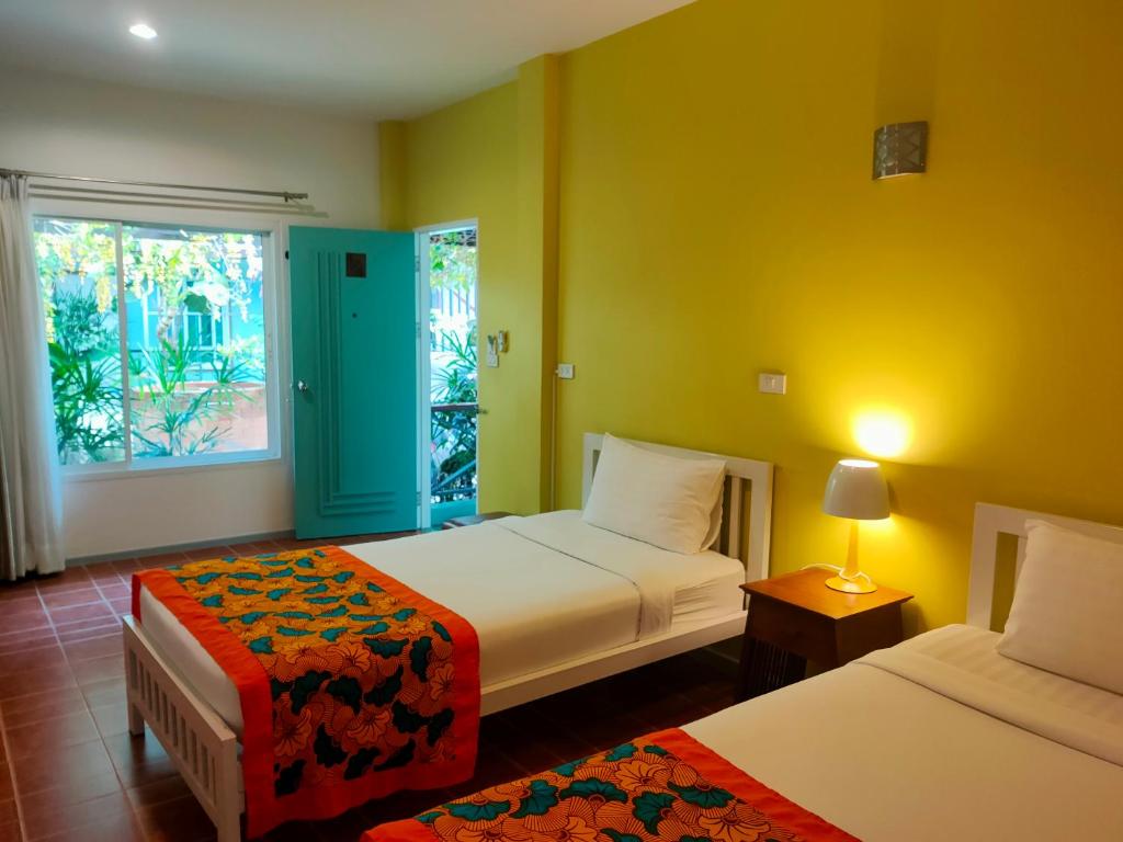 Habitación de hotel con 2 camas y ventana en Baan Jaru en Chiang Rai