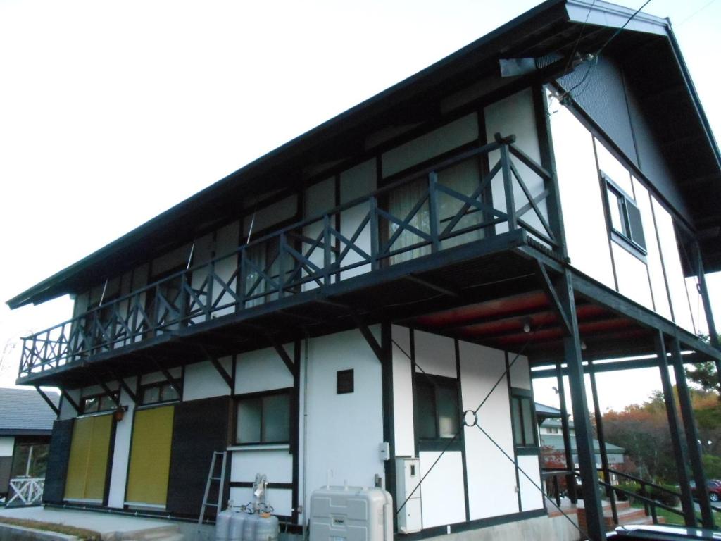 a building with a balcony on the side of it at Villa Nugget Inn in Omachi