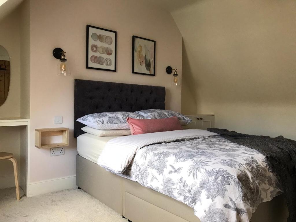 a bedroom with a bed with a black and white comforter at Newly renovated seaside townhouse with logburner in Nairn