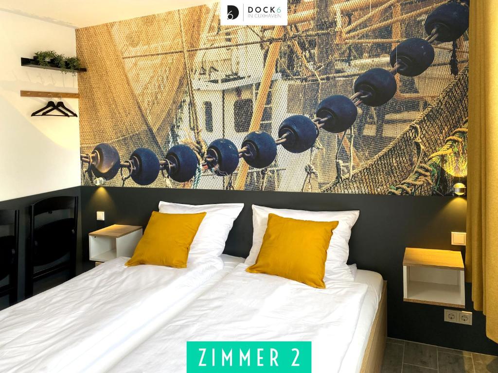- une chambre avec un grand lit et des oreillers jaunes dans l'établissement Dock 6 - Cuxhaven, à Cuxhaven