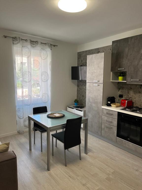 uma cozinha com mesa e cadeiras num quarto em Apartment Verdi BARDOLINO em Bardolino