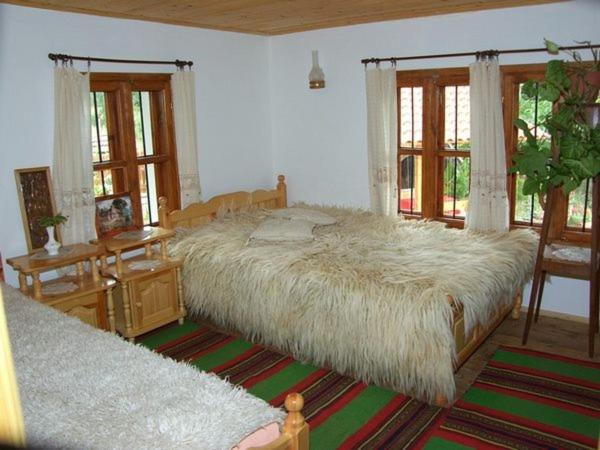 a bedroom with a large bed with a large white comforter at Вила Любима in Yakovtsi