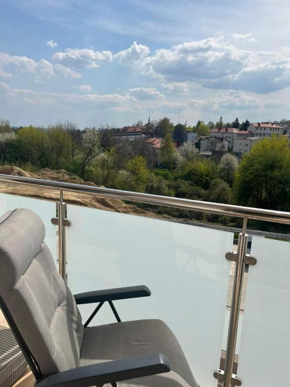 una silla en el balcón con vistas a la ciudad en Apartament na Okrzei, en Sandomierz
