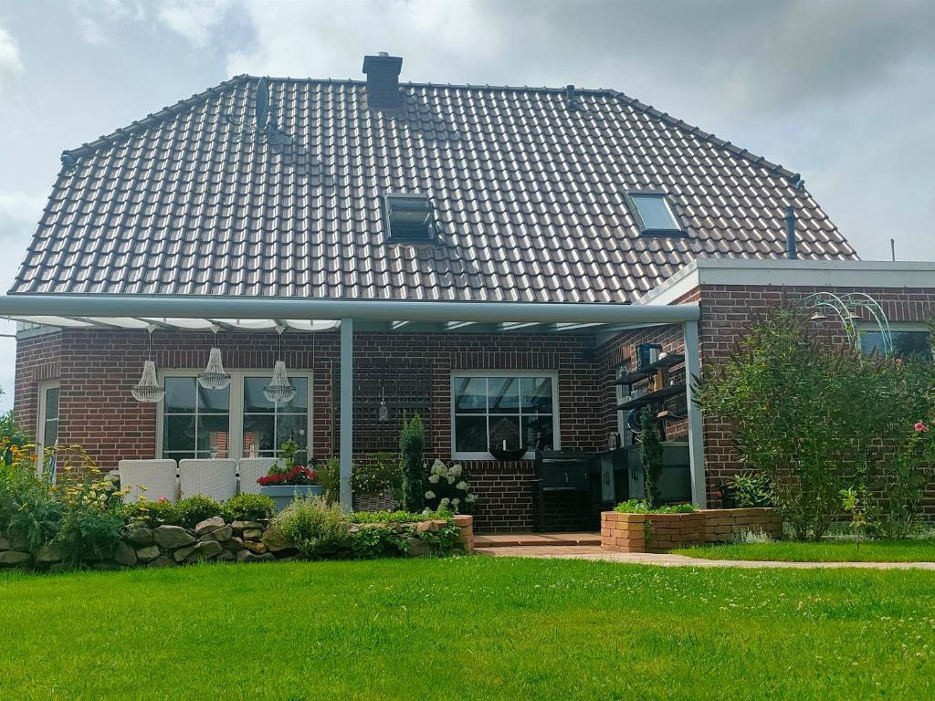 ein Haus mit einem Kacheldach darüber in der Unterkunft Luana`s White Cottage in Surwold