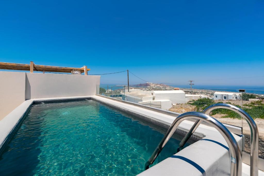 a swimming pool with the ocean in the background at Lami Traditional Windmill - With Private pool and Jacuzzi in Pirgos
