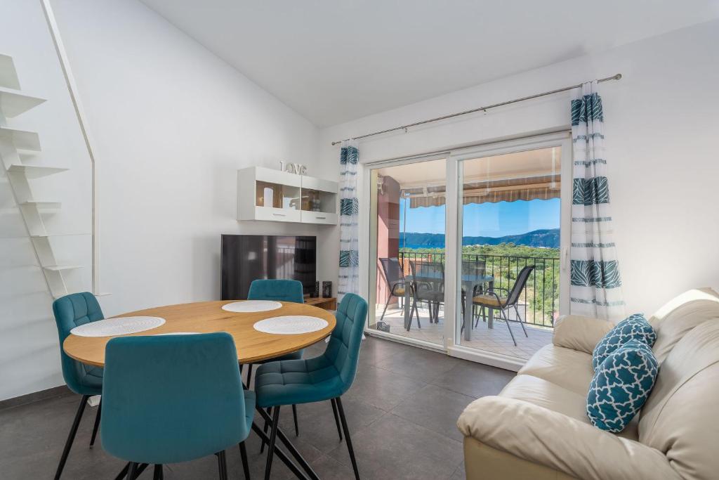 salon ze stołem i krzesłami oraz jadalnią w obiekcie Gallery apartment in Skrbcici (Krk) w mieście Skrbčići