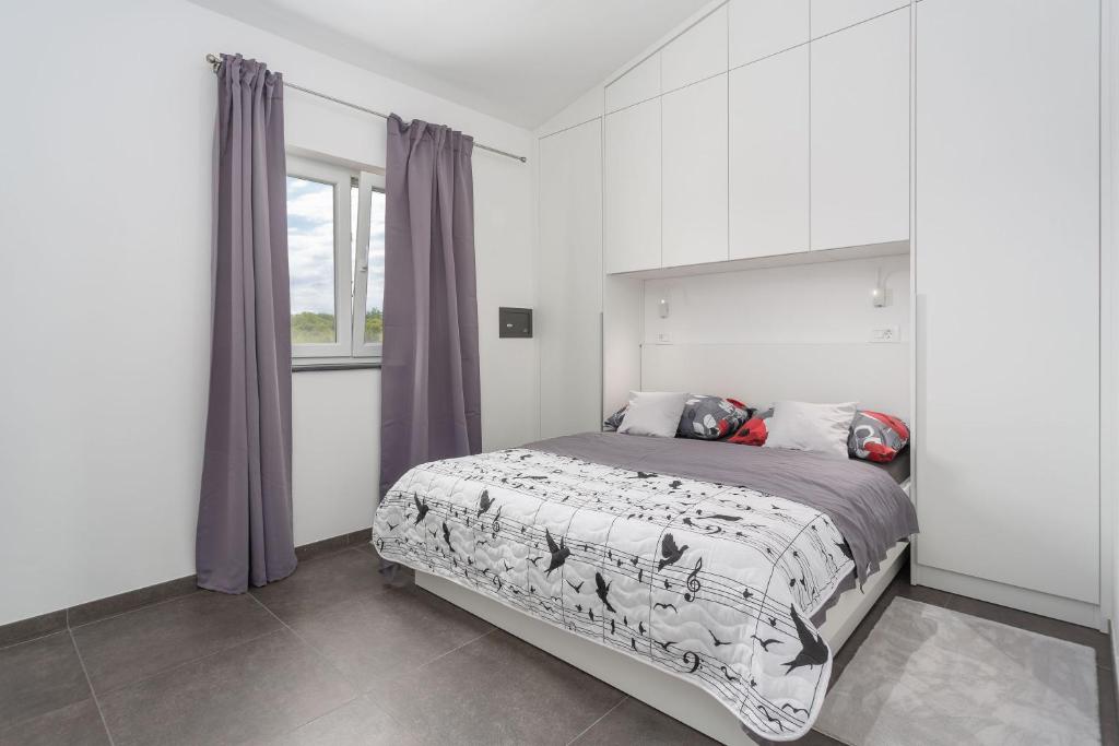 sypialnia z dużym łóżkiem i oknem w obiekcie Gallery apartment in Skrbcici (Krk) w mieście Skrbčići