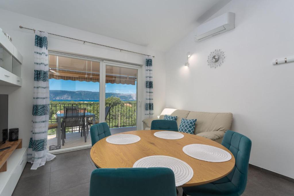 jadalnia z drewnianym stołem i krzesłami w obiekcie Gallery apartment in Skrbcici (Krk) w mieście Skrbčići
