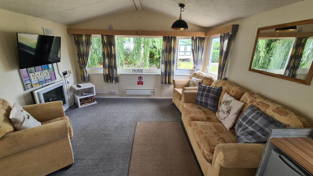 a living room with a couch and a tv at Revamped & Upgraded 6 Berth Static Caravan on Southview Skegness in Skegness