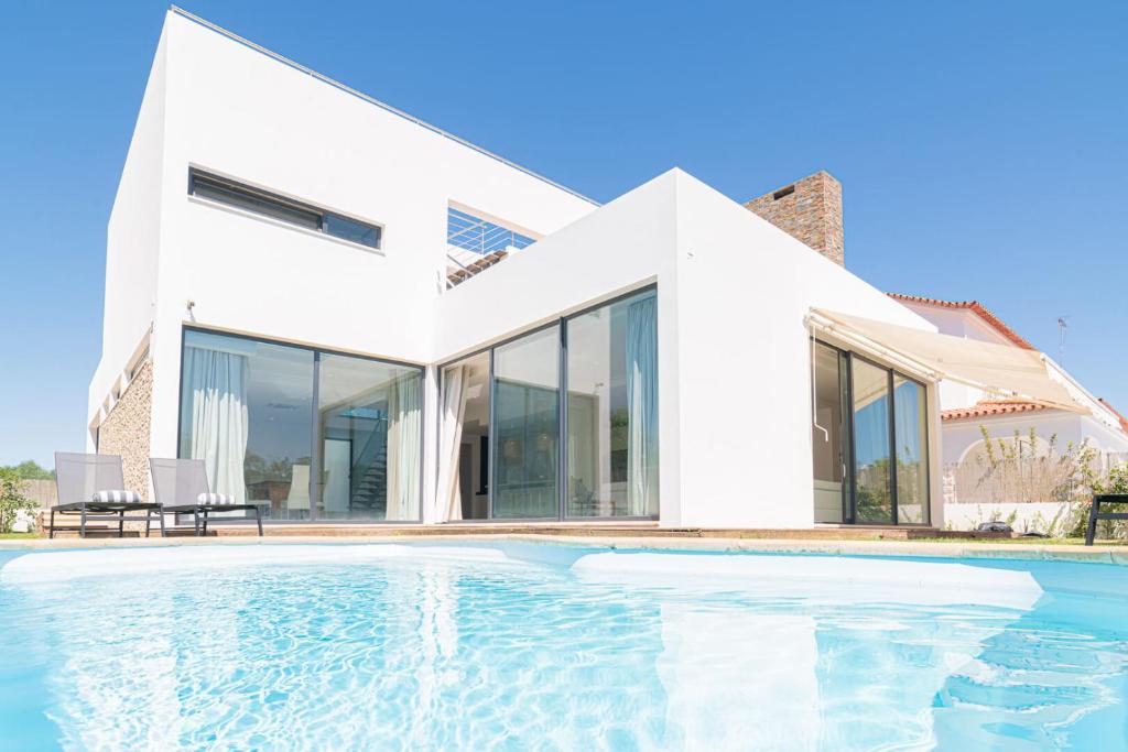uma casa com uma piscina na frente em Villa Melissa em Tróia