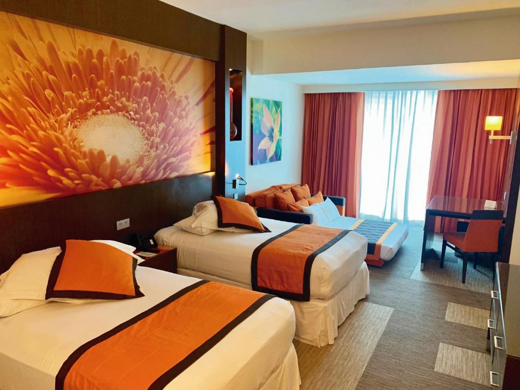 a hotel room with two beds and a table at Riu Plaza Panamá in Panama City