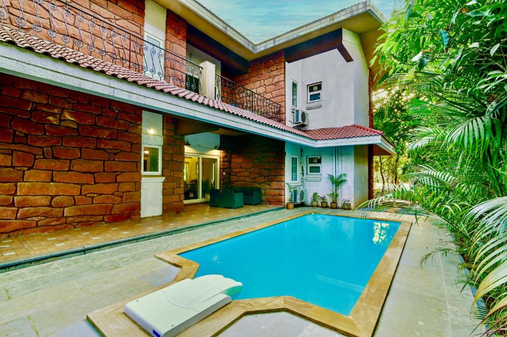 uma piscina em frente a uma casa em SaffronStays Boulevard RockHouse - pool villa with amazing nature views em Lonavala