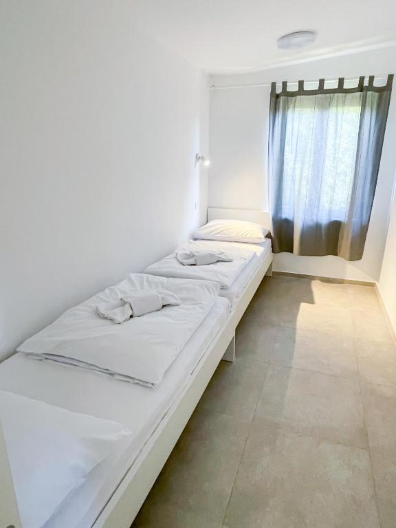 un letto bianco in una stanza con finestra di Tisa Homes a Savudrija
