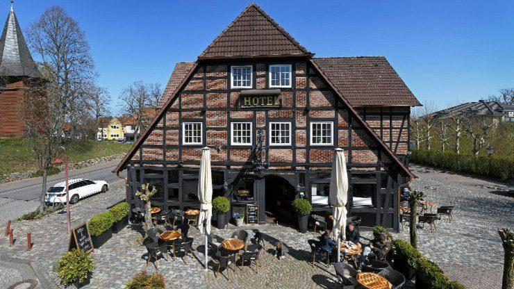 a building with a car parked in front of it at Meyers Hotel Hittfeld in Seevetal