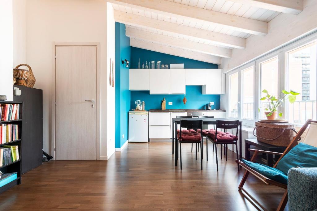 eine Küche mit blauen Wänden sowie einem Tisch und Stühlen in der Unterkunft LUVI - Adda in Mailand