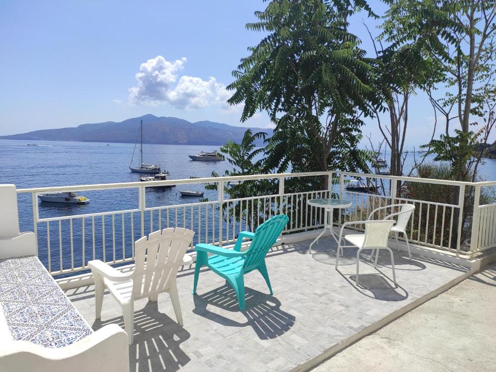 patio con sedie, tavoli e vista sull'acqua di Aeolian Sea House a Santa Marina Salina