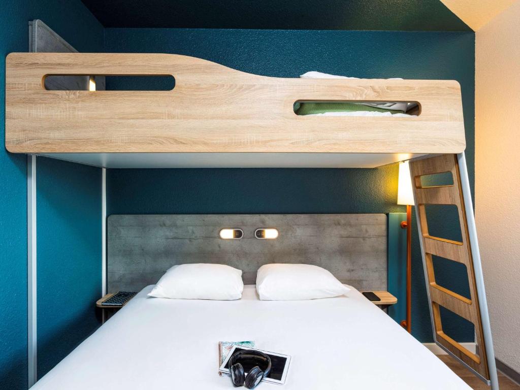 a bedroom with a bunk bed with a ladder at ibis budget Paris Porte d'Italie Est in Le Kremlin-Bicêtre