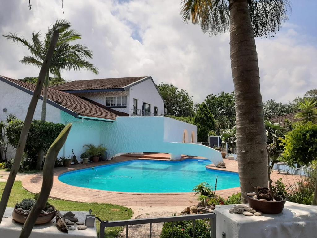 a swimming pool in front of a house at Umuzi Guest House in Richards Bay