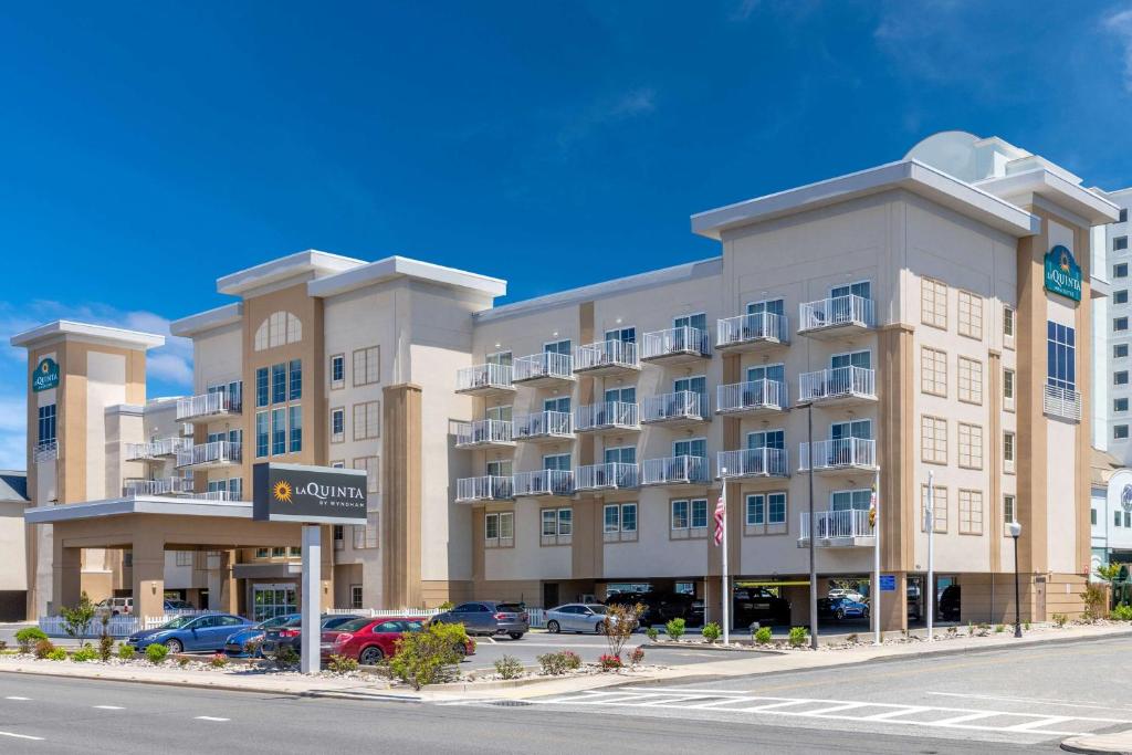 a large building with cars parked in a parking lot at La Quinta by Wyndham Ocean City in Ocean City