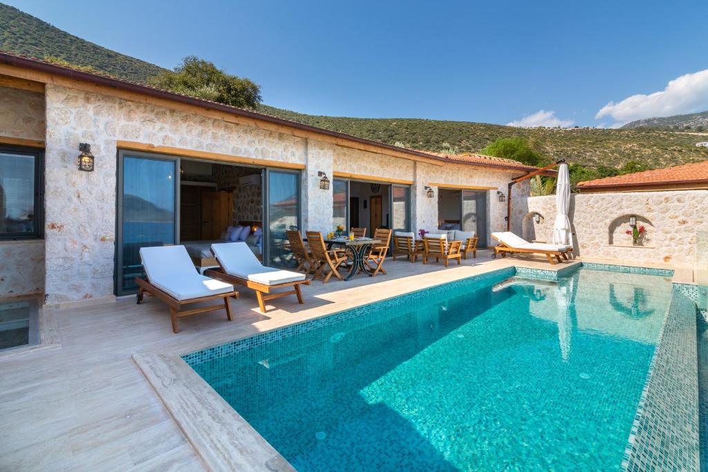 a villa with a swimming pool and a patio at Water Edge 3 in Kaş