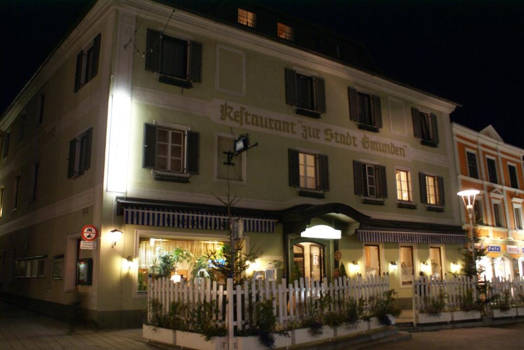 ein großes Gebäude mit einem weißen Zaun davor in der Unterkunft Hotel Krmstl "Zur Stadt Gmunden" in Kirchdorf an der Krems
