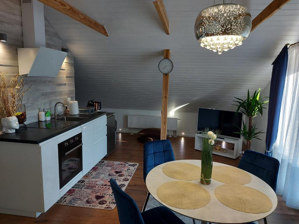 a kitchen and living room with a table and chairs at Apartments MILENA in Druskininkai