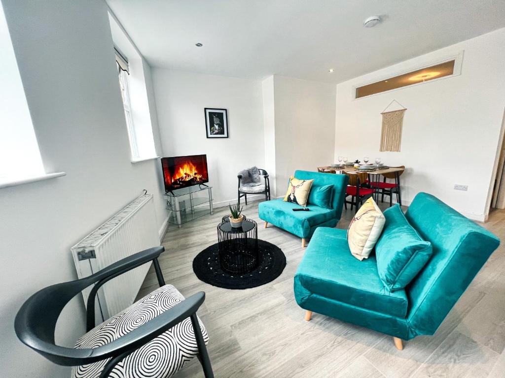 a living room with two blue couches and a fireplace at The County Staycation in Liverpool