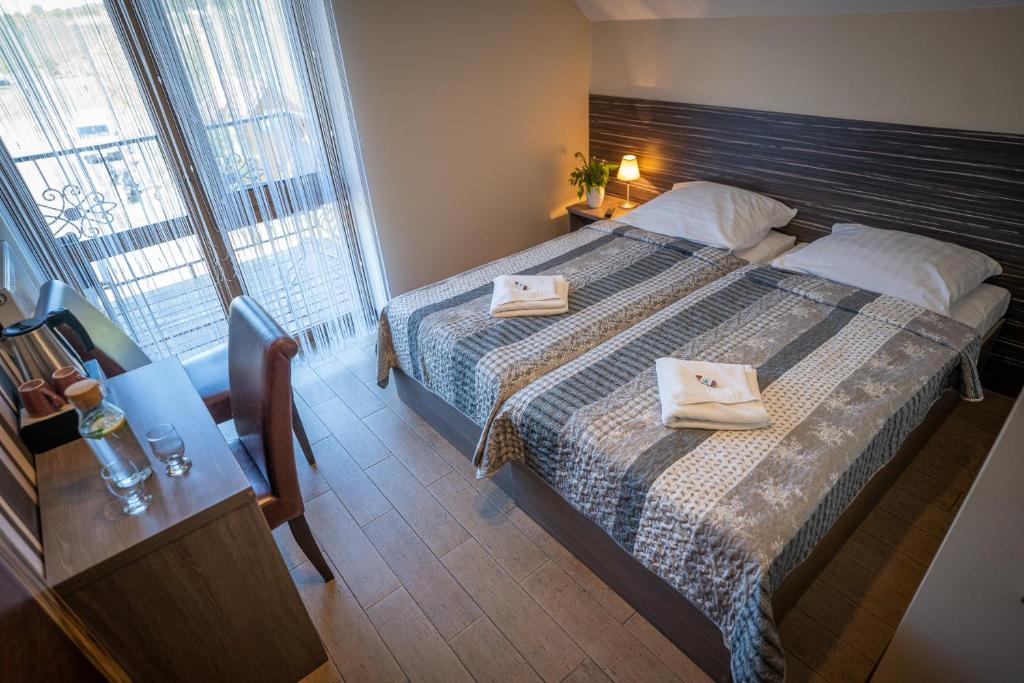 um quarto de hotel com uma cama com duas toalhas em Osada Koszałkowo Wieżyca em Szymbark
