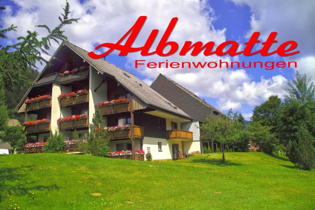 un grand bâtiment sur une colline herbeuse avec les mots al harmonie ferwegian dans l'établissement B3 Ferienwohnubg im Schwarzwald, à Menzenschwand