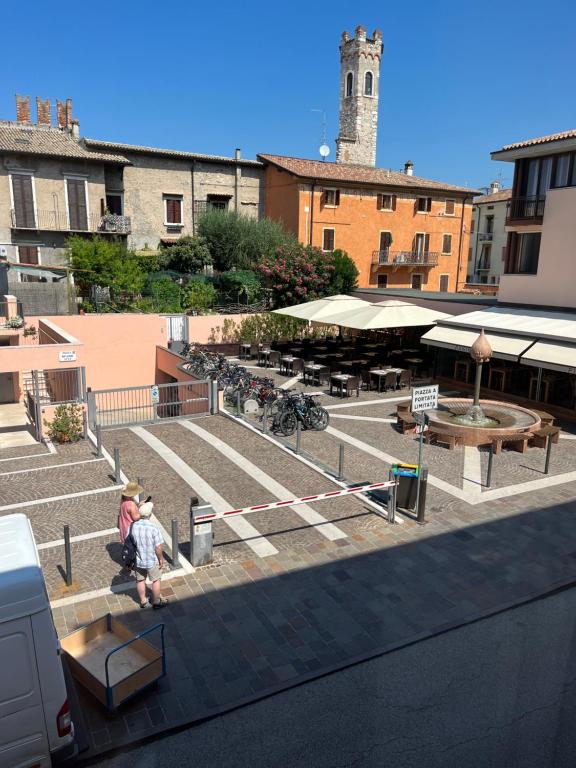 dwoje ludzi siedzących na schodach budynku w obiekcie Apartment Verdi BARDOLINO w mieście Bardolino