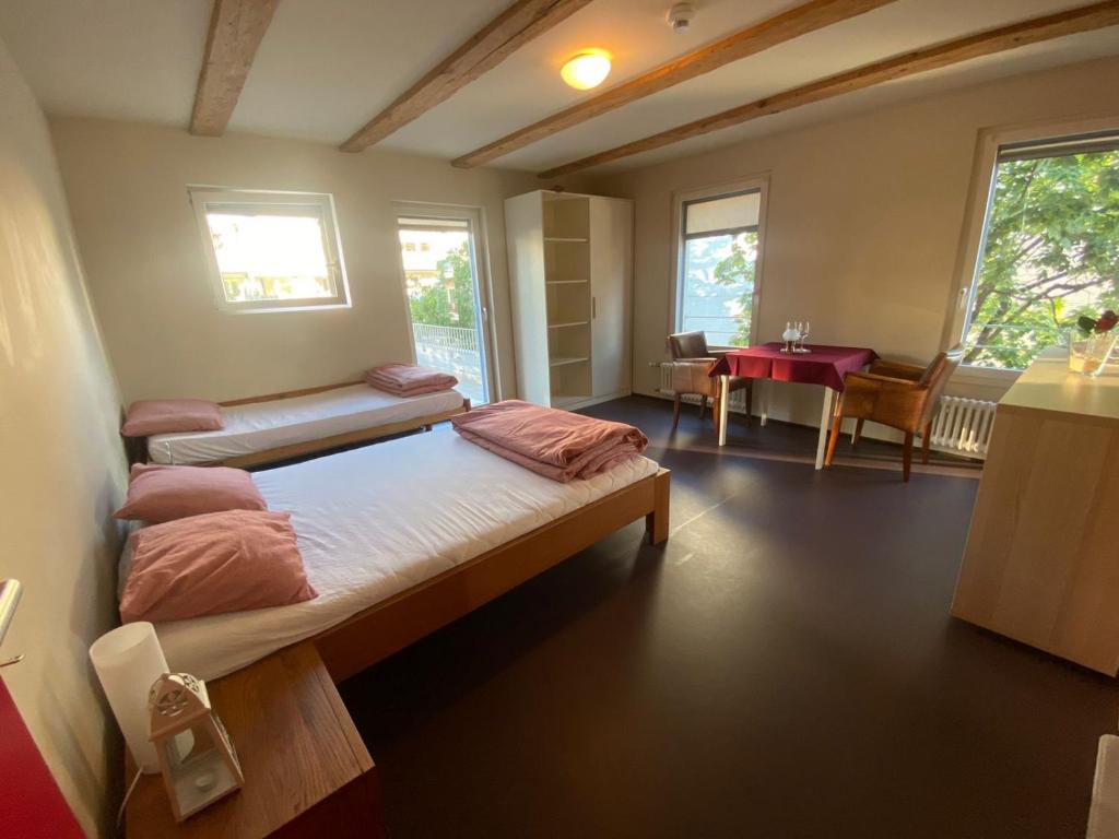 - une chambre avec 2 lits et une table dans l'établissement Zyba-Hotelzimmer-Vermietung Aesch Kanton Luzern, à Aesch