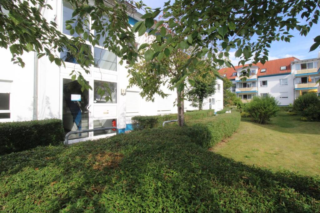 een persoon die in de deuropening van een wit huis staat bij Fewo Strandrevier in Zingst