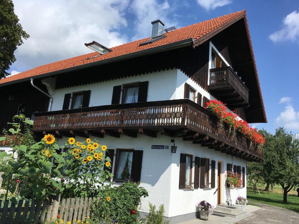 a white house with a balcony and sunflowers at Aich21 in Peißenberg