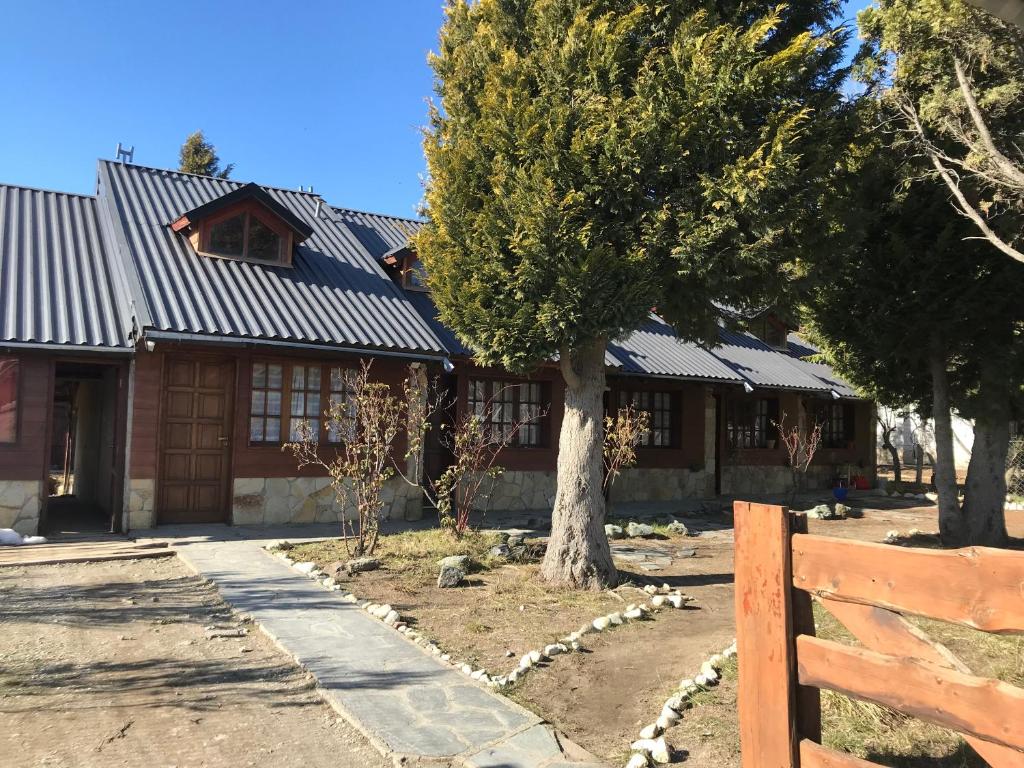 una casa con un árbol delante en Nueva Serena, en San Carlos de Bariloche